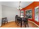 Cozy dining room with wood floors, orange accent wall, and large windows with outside views at 4511 Preston Woods Dr, Valrico, FL 33596