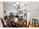 Open dining area with dark wood table, chandelier, wood floors, and views into the living room at 4511 Preston Woods Dr, Valrico, FL 33596