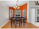 Comfortable dining room with dark wood table and chairs, bay windows, and modern chandelier at 4511 Preston Woods Dr, Valrico, FL 33596