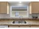 Kitchen sink and granite countertop, featuring stainless steel sink fixtures with cabinet and window views at 4511 Preston Woods Dr, Valrico, FL 33596