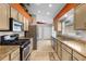 Well-lit kitchen with neutral cabinets, granite countertops, stainless steel appliances, and tile flooring at 4511 Preston Woods Dr, Valrico, FL 33596