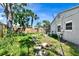 The backyard with stepping stones features a wooden fence, mature trees, and ample green space at 4735 Baywood Point S Dr, Gulfport, FL 33711