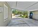 Attached carport showcasing ample parking space with view of trees, garden, and neighborhood street at 4735 Baywood Point S Dr, Gulfport, FL 33711