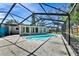 This image features a screened-in pool area with a turquoise pool, concrete patio, and view of the home's exterior at 4735 Baywood Point S Dr, Gulfport, FL 33711