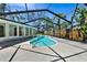 Screened-in pool area with a sparkling pool, concrete deck, and tropical landscaping offering a relaxing outdoor space at 4735 Baywood Point S Dr, Gulfport, FL 33711