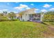 Expansive backyard view showcasing the house, screen porch, and vibrant flowers at 5270 White Sand Ne Cir, St Petersburg, FL 33703