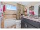 Well-lit bathroom features tiled walls, decorative mirror, stylish vanity, and a bathtub with a shower at 5270 White Sand Ne Cir, St Petersburg, FL 33703