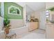 Bright bathroom with tiled floors, tiled bathtub and a window offering lush outdoor views at 5270 White Sand Ne Cir, St Petersburg, FL 33703