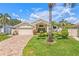 Charming home with a two-car garage, brick driveway, and landscaped front yard with a palm tree at 5270 White Sand Ne Cir, St Petersburg, FL 33703