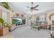 Bright living room features a ceiling fan, a fireplace and large windows with lush landscaping views at 5270 White Sand Ne Cir, St Petersburg, FL 33703