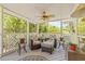 Screened in lanai featuring comfortable seating, ceiling fan and peaceful views of lush landscaping at 5270 White Sand Ne Cir, St Petersburg, FL 33703