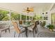 Covered patio with dining table, ceiling fans, and views of tropical trees and landscaping at 5270 White Sand Ne Cir, St Petersburg, FL 33703