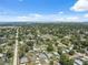 Vast aerial view of a suburban landscape featuring a variety of homes, lush trees, and a distant view of the bay at 6209 S Harold Ave, Tampa, FL 33616