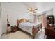 Cozy bedroom with ceiling fan, wood furniture, and window with curtains at 6209 S Harold Ave, Tampa, FL 33616