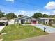 Charming single Gathering home with a red garage door, a manicured lawn, and blue skies at 6209 S Harold Ave, Tampa, FL 33616
