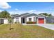 Charming single-story home featuring a red garage door, stone accents, and well-maintained landscaping at 6209 S Harold Ave, Tampa, FL 33616