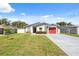 Charming single-story home with a well-manicured lawn and a bright red garage door at 6209 S Harold Ave, Tampa, FL 33616