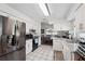 Open kitchen with granite countertops, stainless steel refrigerator, and white cabinetry at 6209 S Harold Ave, Tampa, FL 33616