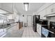 Well-lit kitchen with white cabinets, stainless steel appliances, and tile flooring at 6209 S Harold Ave, Tampa, FL 33616