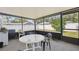 Enclosed porch with white plastic table and chairs, and a black frame enclosing screens at 6209 S Harold Ave, Tampa, FL 33616