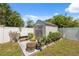 Outdoor shed with gray doors, surrounded by potted plants and white privacy fence at 6209 S Harold Ave, Tampa, FL 33616