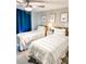 Stylish bedroom with two beds featuring striped bedding, coastal-themed artwork, and a ceiling fan at 690 Fox St, Longboat Key, FL 34228