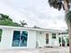Inviting exterior with white facade, glass sliding door, and classic Adirondack chairs on the porch at 690 Fox St, Longboat Key, FL 34228
