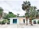 Charming cottage-style home with palm trees, white gravel landscaping, and a welcoming front porch at 690 Fox St, Longboat Key, FL 34228