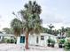 Cute, light blue cottage with palm trees, and white gravel enhancing the curb appeal at 690 Fox St, Longboat Key, FL 34228