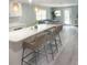 Modern kitchen with island seating and open-concept floor plan to the living area at 690 Fox St, Longboat Key, FL 34228