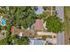 An aerial view shows a home surrounded by mature trees, sheds, and a driveway with a car at 762 77Th N Ave, St Petersburg, FL 33702
