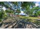 Large back yard featuring mature trees, a fire pit, and a covered area at 762 77Th N Ave, St Petersburg, FL 33702