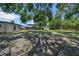 Large back yard featuring mature trees, a fire pit, and a covered area at 762 77Th N Ave, St Petersburg, FL 33702