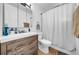 Updated bathroom with a modern vanity, toilet, and shower with a white curtain at 762 77Th N Ave, St Petersburg, FL 33702