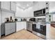 Well-equipped kitchen with white cabinets, stainless steel appliances, and tile flooring at 762 77Th N Ave, St Petersburg, FL 33702