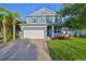 Charming two-story home featuring a two-car garage, inviting front porch, and well-manicured lawn at 7703 S West Shore Blvd, Tampa, FL 33616