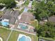 Aerial view of a home with a screened pool area, surrounded by lush landscaping and neighboring houses at 8306 N Gomez Ave, Tampa, FL 33614