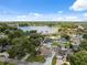 Aerial view of a home featuring a large pool in a lush, green neighborhood near a lake at 8306 N Gomez Ave, Tampa, FL 33614