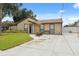 Exterior of a well-maintained home featuring a manicured lawn and long driveway at 8306 N Gomez Ave, Tampa, FL 33614