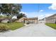 Charming single-story home with a well-manicured lawn and long driveway at 8306 N Gomez Ave, Tampa, FL 33614