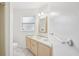 Bright bathroom with a modern sink vanity, white walls, and a decorative mirror at 8500 144Th Ln, Seminole, FL 33776
