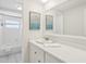 Bright bathroom features a long vanity with a large mirror and white cabinets, adjacent to the shower/tub at 8500 144Th Ln, Seminole, FL 33776