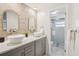Bright bathroom featuring a double vanity, stylish mirrors, and a glass enclosed shower at 8500 144Th Ln, Seminole, FL 33776