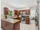 Well-lit kitchen featuring wood cabinets, granite countertops, and stainless steel appliances at 8500 144Th Ln, Seminole, FL 33776
