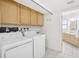 A laundry room with washer and dryer hookups, storage cabinets and easy access to the bathroom at 8500 144Th Ln, Seminole, FL 33776