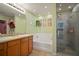 Well-lit bathroom with double sinks, a soaking tub, and a glass-enclosed shower at 8607 Tidal Breeze Dr, Riverview, FL 33569