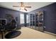 Bedroom with striking wallpaper, a ceiling fan, and glass display cabinets at 8607 Tidal Breeze Dr, Riverview, FL 33569