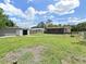 A spacious, fenced-in backyard with a well-maintained lawn and a screened-in patio at 9413 Forest Hills Dr, Tampa, FL 33612