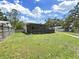 A fenced-in backyard features a well-maintained lawn and a screened-in patio at 9413 Forest Hills Dr, Tampa, FL 33612