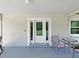 Cozy front porch with neutral paint, a white door, and comfortable seating, perfect for relaxing outdoors at 9413 Forest Hills Dr, Tampa, FL 33612